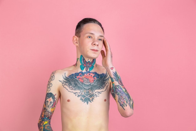 Retrato, de, joven, con, tatuajes, en, pared rosa