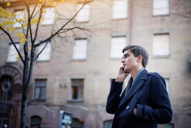 Retrato de un joven con un teléfono en sus manos.