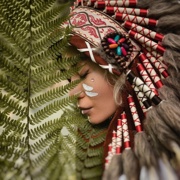 retrato de una joven con tocados nativos americanos contra el fondo de la naturaleza