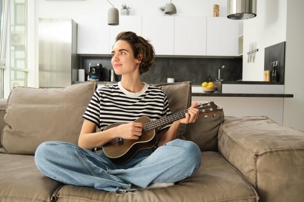 Foto retrato de un joven tocando la guitarra en casa