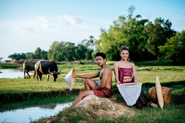 Retrato de joven en topless sentado cerca de una mujer bonita en ropa hermosa en el estilo de vida rural