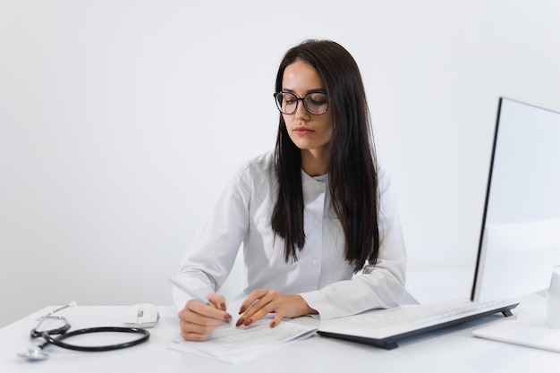 Retrato de una joven trabajadora médica que escribe una receta