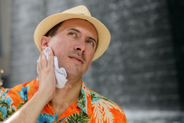 Retrato de joven turista guapo fuera del centro comercial de la ciudad