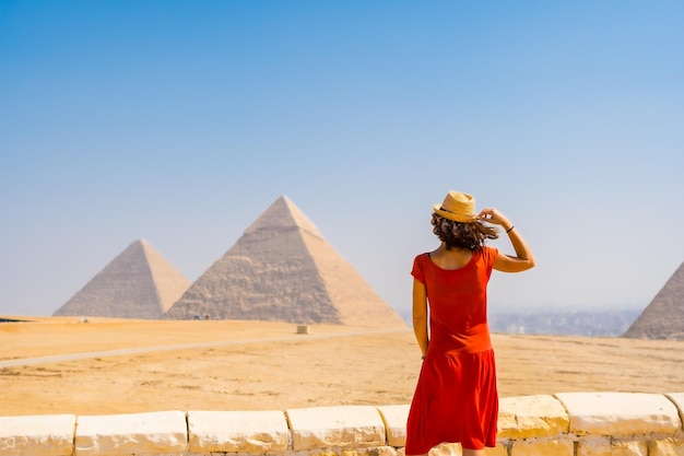 Retrato de un joven turista vestido de rojo disfrutando de las pirámides de Giza