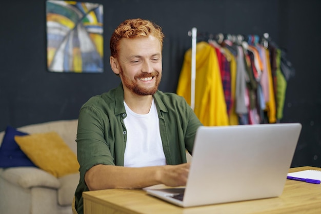 Retrato de un joven usando una computadora portátil en la mesa