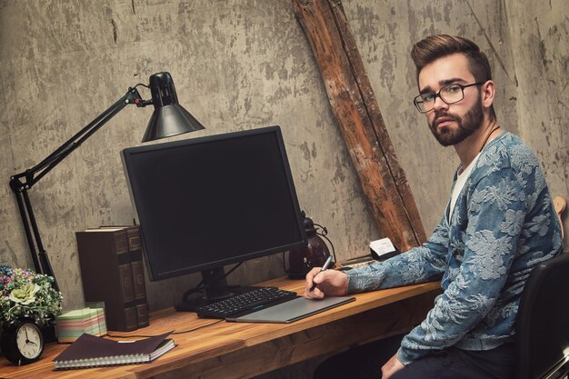Retrato de un joven usando una computadora portátil en la mesa