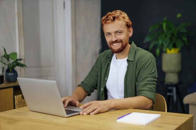 Retrato de un joven usando una computadora portátil en la oficina