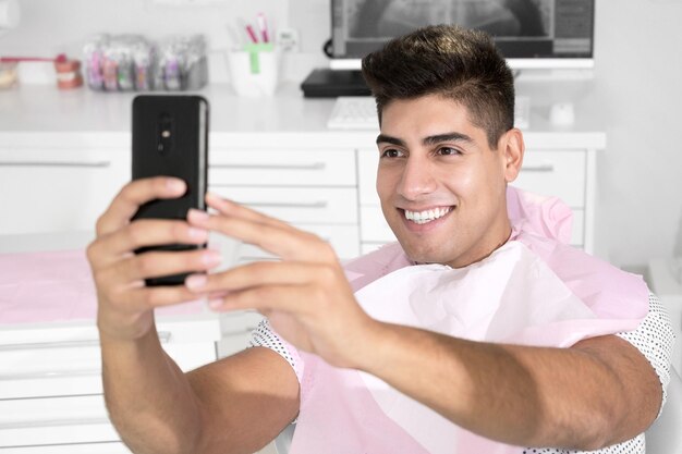 Foto retrato de un joven usando un teléfono móvil