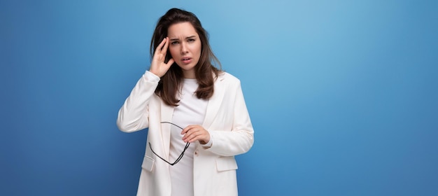 Retrato de una joven con un vestido blanco y gafas con dolor de cabeza