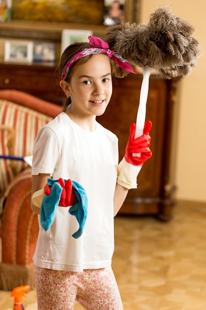 Retrato de jovencita limpieza salón con paño y cepillo de plumas