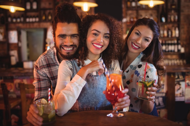 Retrato de jóvenes amigos tomando bebidas