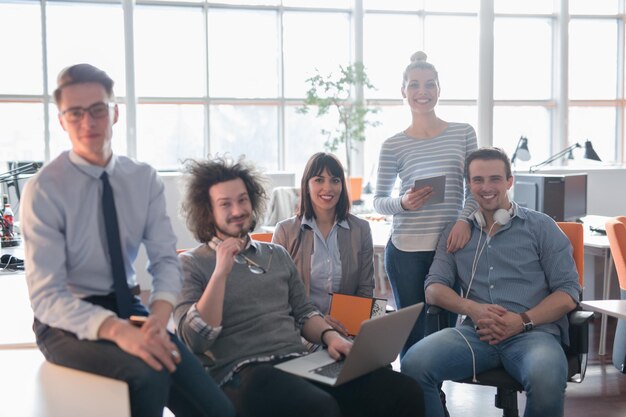 Retrato de jóvenes empresarios discutiendo el plan de negocios en la oficina