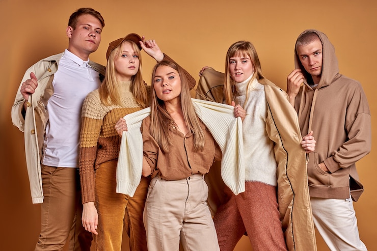 Foto retrato de jóvenes con estilo de moda posando en cámara aislada sobre fondo marrón