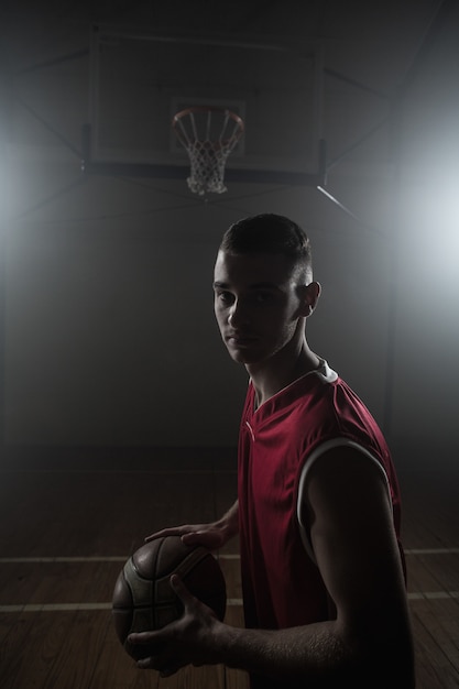 Retrato del jugador de baloncesto sosteniendo una pelota