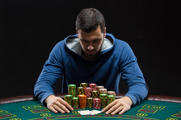 Retrato de un jugador de póquer profesional sentado en la mesa de póquer