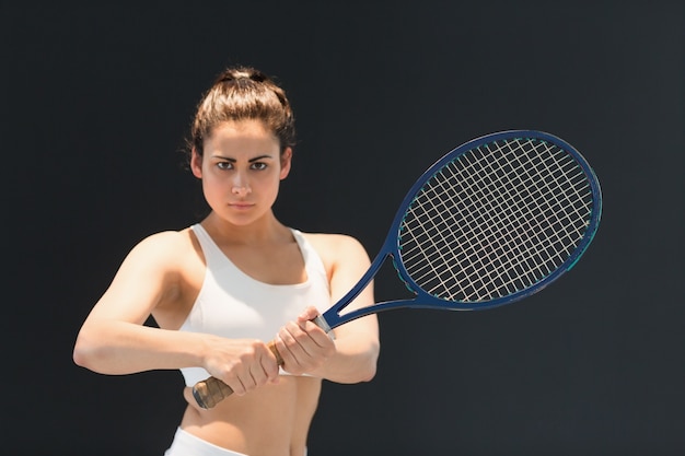 Retrato del jugador de tenis femenino confidente con la raqueta