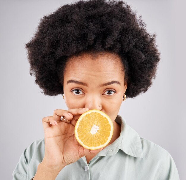 Retrato laranja e fruta negra em estúdio isolado em um fundo branco Nutricionista de rosto de comida e pessoa séria ou mulher com nutrição de vitamina c ou dieta saudável cítrica ou desintoxicação vegana