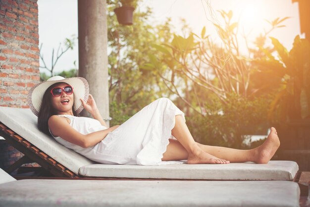 Foto retrato de larga duración de una joven feliz relajándose en una silla de descanso en el patio