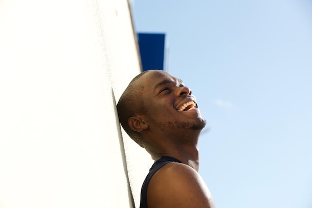 Retrato lateral do jovem negro rindo