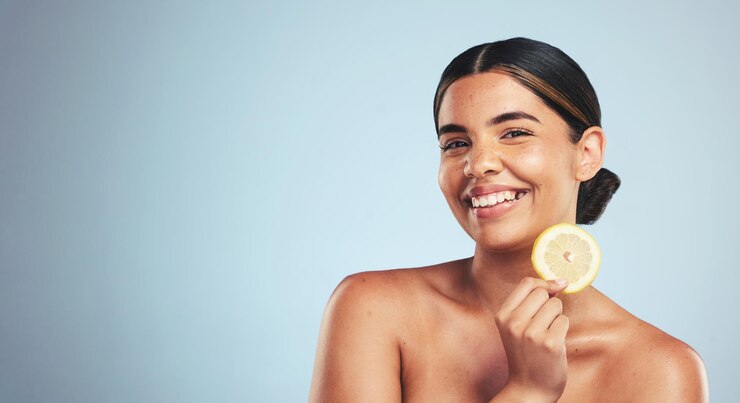 Foto retrato de limón y mujer feliz en estudio para el bienestar del cuidado de la piel o belleza orgánica o desintoxicación de la piel sobre fondo gris sonrisa de fruta y cara de modelo de dama con facial cítrico para colágeno o antienvejecimiento