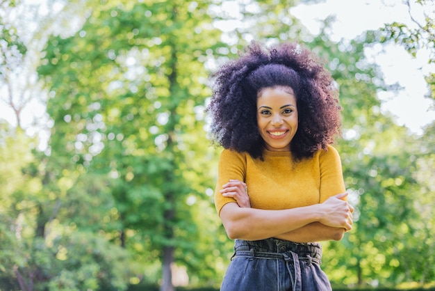 Retrato de linda chica afro en un jardín. Tiro medio. Enfoque selectivo.