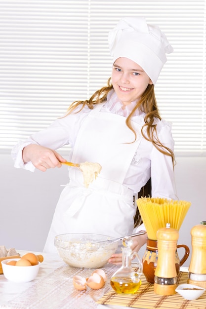 Retrato de linda chica cocinando en la cocina