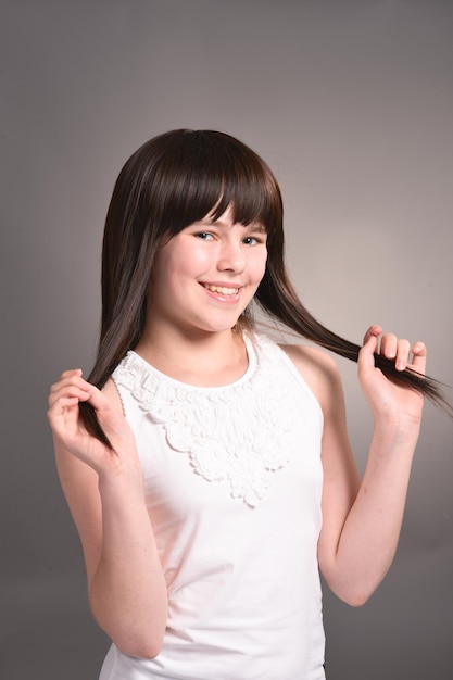 Retrato de linda chica feliz con cabello oscuro posando