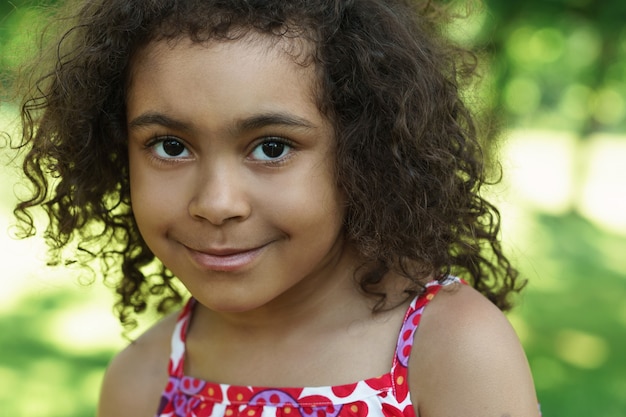 Retrato de linda chica negra en un parque de la ciudad