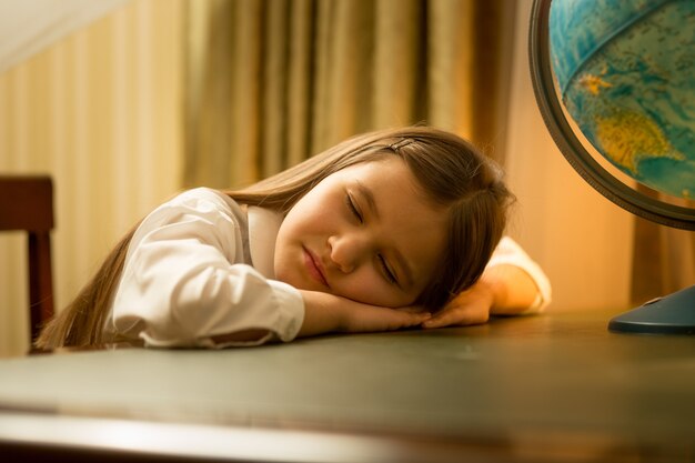 Foto retrato de linda chica se quedó dormida mientras hacía los deberes