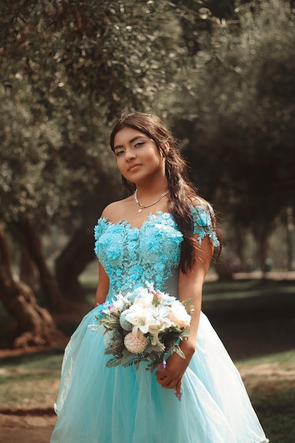 Retrato de una linda chica con vestido azul celebrando sus 15