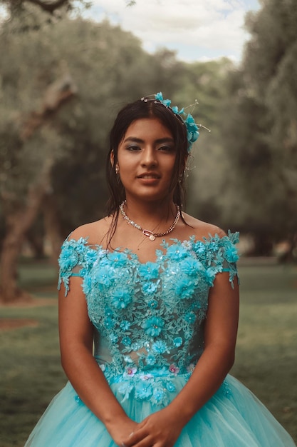 Retrato de una linda chica con vestido azul celebrando sus 15