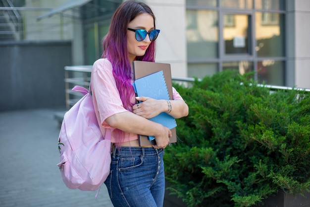 Retrato linda escritora vestida com roupa casual segurando um laptop moderno na mão com