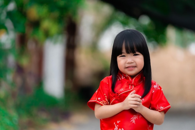 Retrato linda garotinha asiática no vestido CheongsamPovo da TailândiaFeliz ano novo chinêsconceitoFeliz garotinha asiática no vestido tradicional chinês