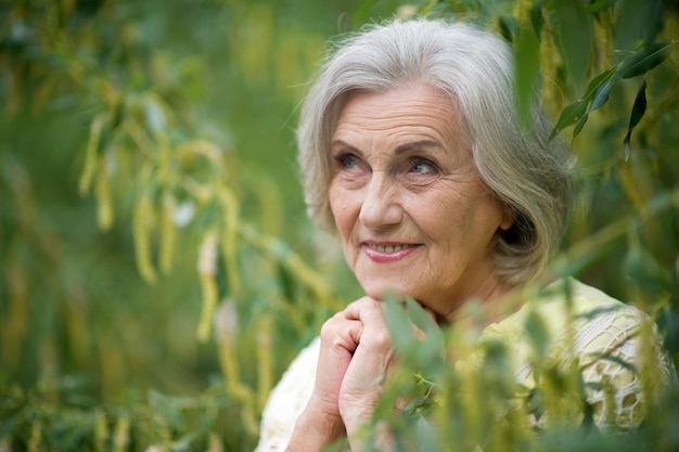 Retrato de una linda y hermosa anciana en un parque verde