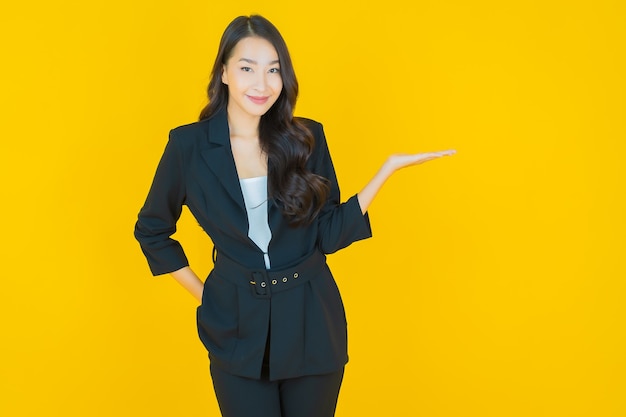 Retrato linda jovem asiática sorrindo com ação em amarelo