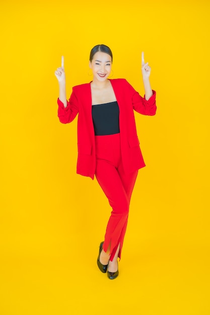 Retrato linda jovem asiática sorrindo com ação em amarelo