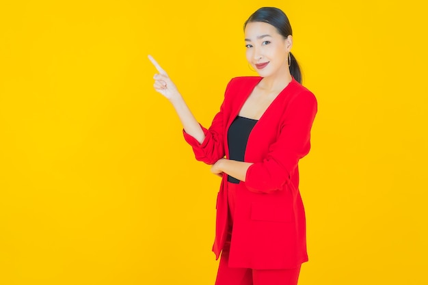 Retrato linda jovem asiática sorrindo com ação em amarelo