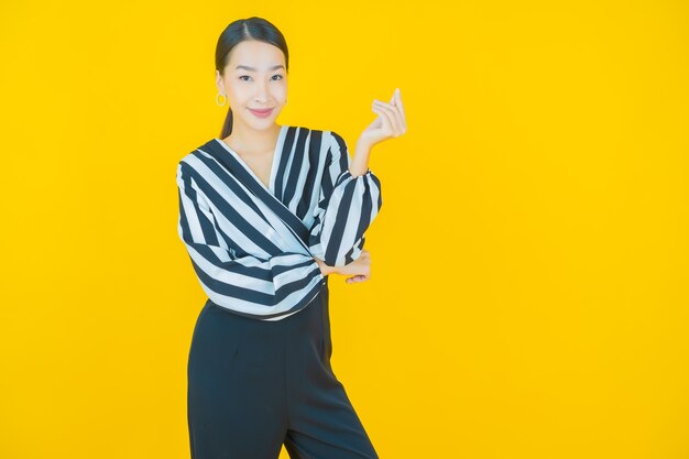 Retrato linda jovem asiática sorrindo em amarelo