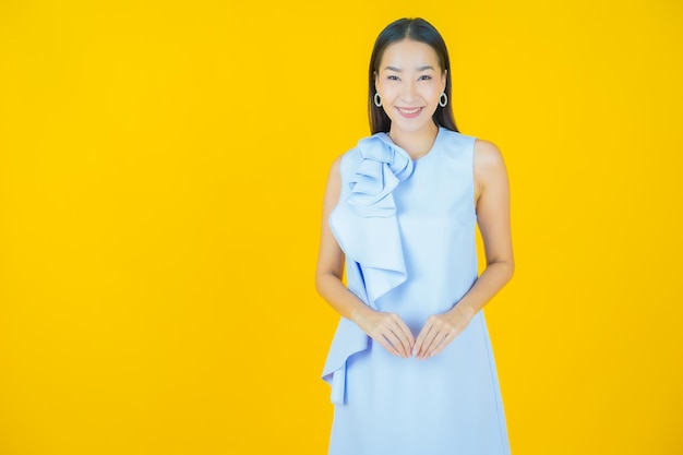 Retrato linda jovem asiática sorrindo em amarelo