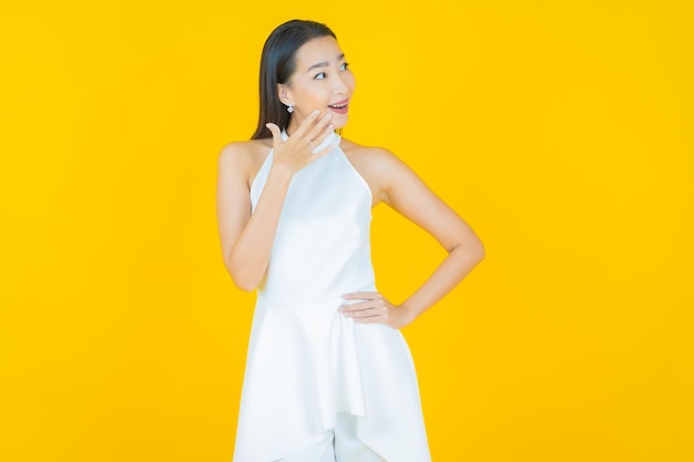 Retrato linda jovem mulher asiática sorrindo em amarelo