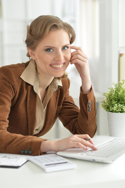 Retrato de linda joven empresaria en su lugar de trabajo