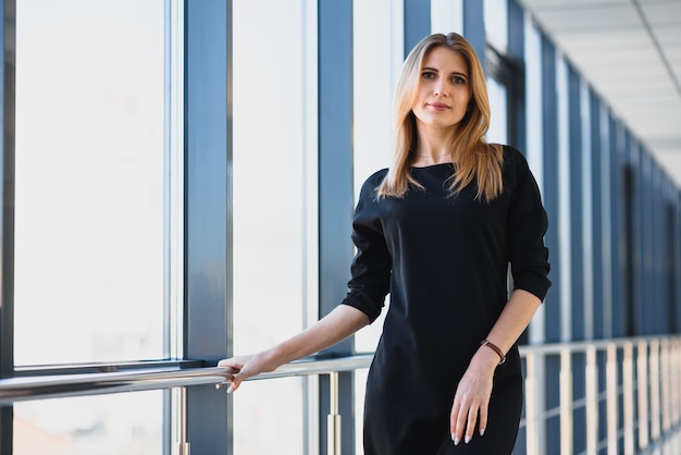 Retrato de una linda joven mujer de negocios sonriendo, en un entorno de oficina