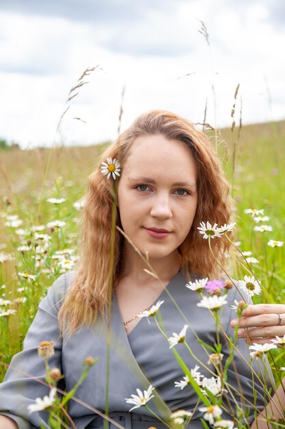 Retrato de una linda joven vestida con flores silvestres en verano