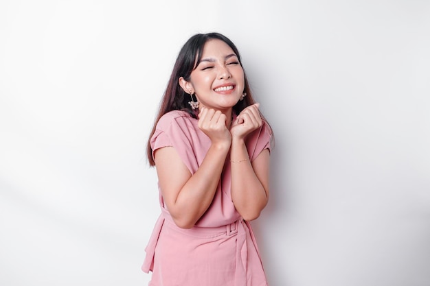 Un retrato de una linda mujer asiática vestida de rosa y sintiéndose emocionada y aislada por un fondo blanco