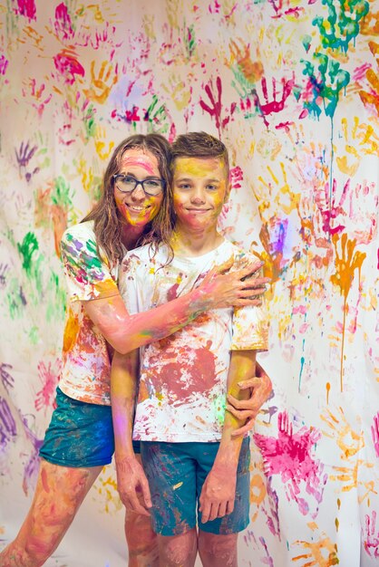 Retrato de una linda mujer feliz con su hijo pintando y divirtiéndose