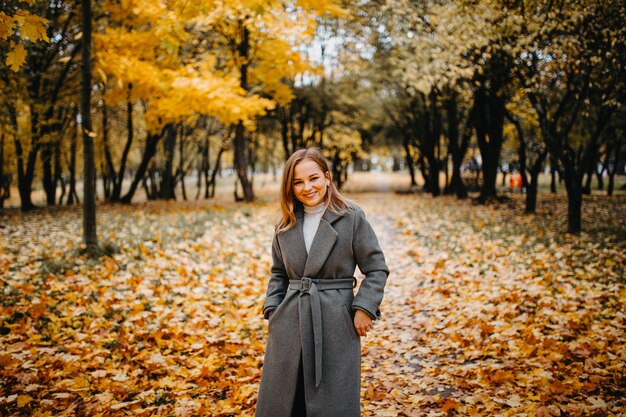 Retrato de una linda mujer en otoño caminando en el parque de otoño