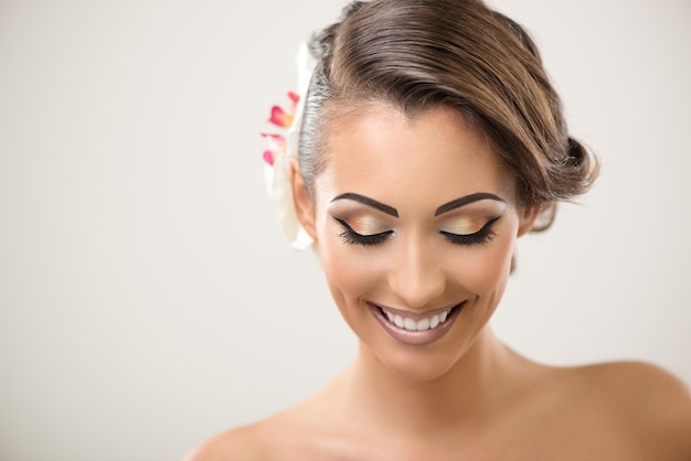 Retrato de una linda mujer sonriente con un bonito maquillaje posando en un estudio.