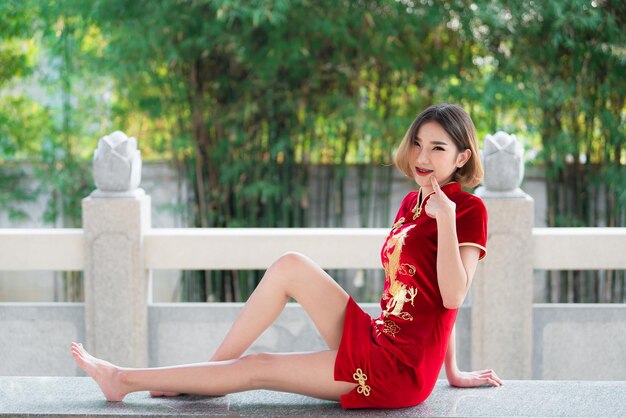 Retrato linda mulher asiática no vestido Cheongsampovo da TailândiaFeliz ano novo chinêsconceitoFeliz senhora asiática no vestido tradicional chinês