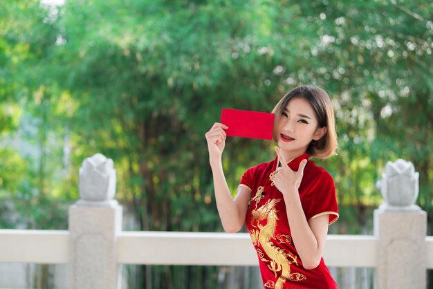 Retrato linda mulher asiática no vestido Cheongsampovo da TailândiaFeliz ano novo chinêsconceitoFeliz senhora asiática no vestido tradicional chinês
