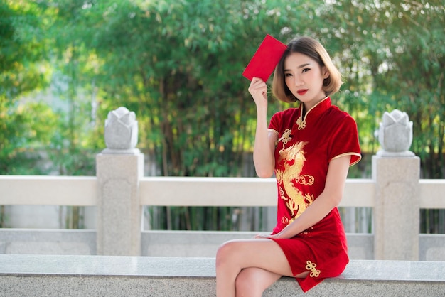 Retrato linda mulher asiática no vestido Cheongsampovo da TailândiaFeliz ano novo chinêsconceitoFeliz senhora asiática no vestido tradicional chinês